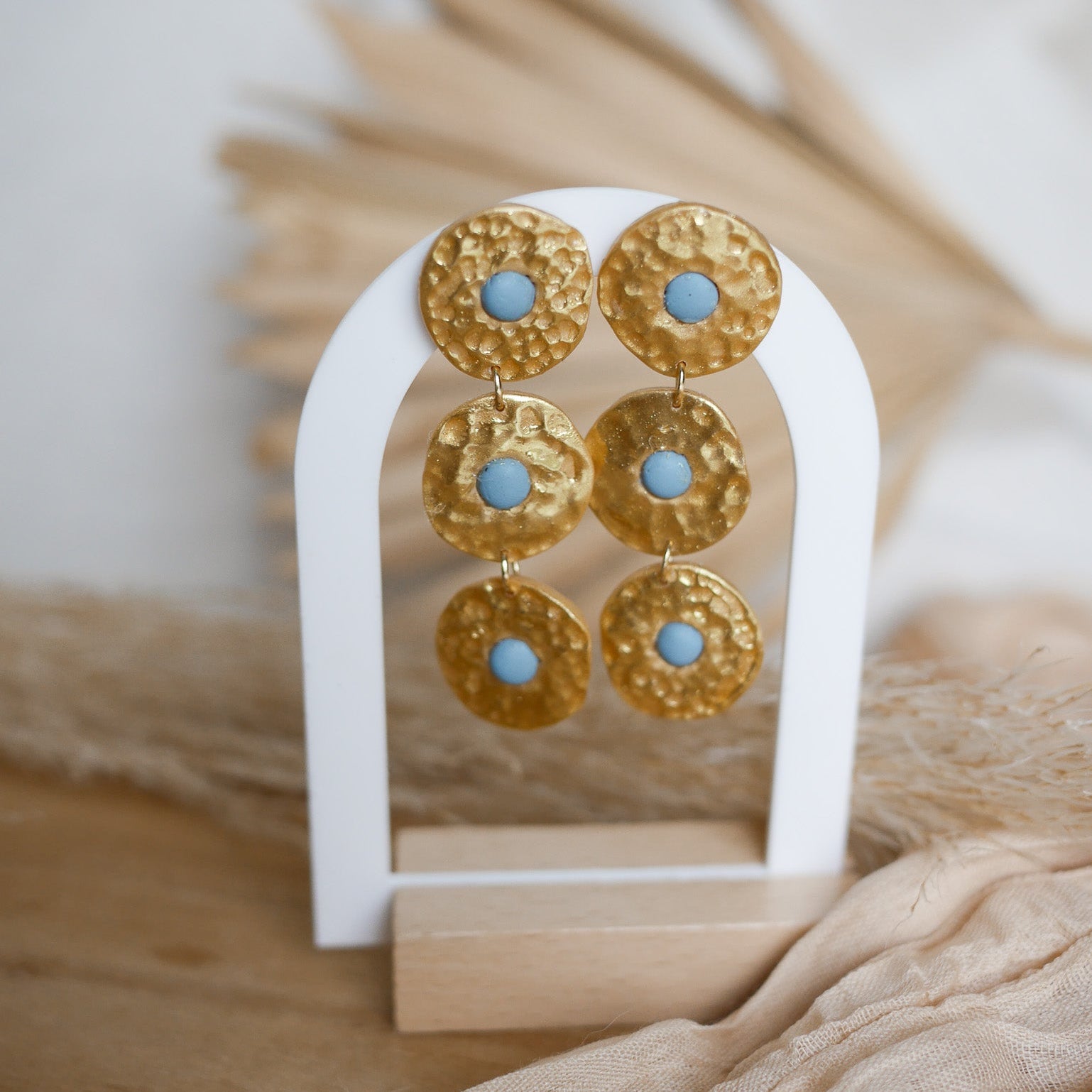Boucles d’oreilles Byron en pâte polymère dorée, effet martelé, trois pièces articulées.
