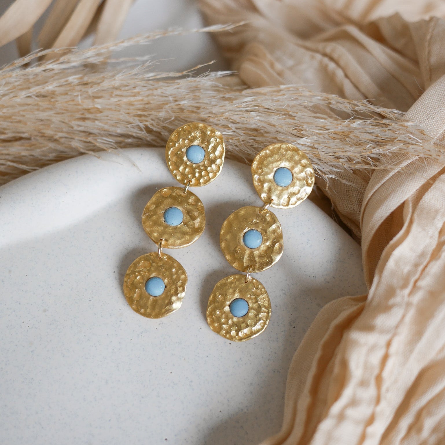 Boucles d’oreilles Byron en pâte polymère dorée, effet martelé, trois pièces articulées.