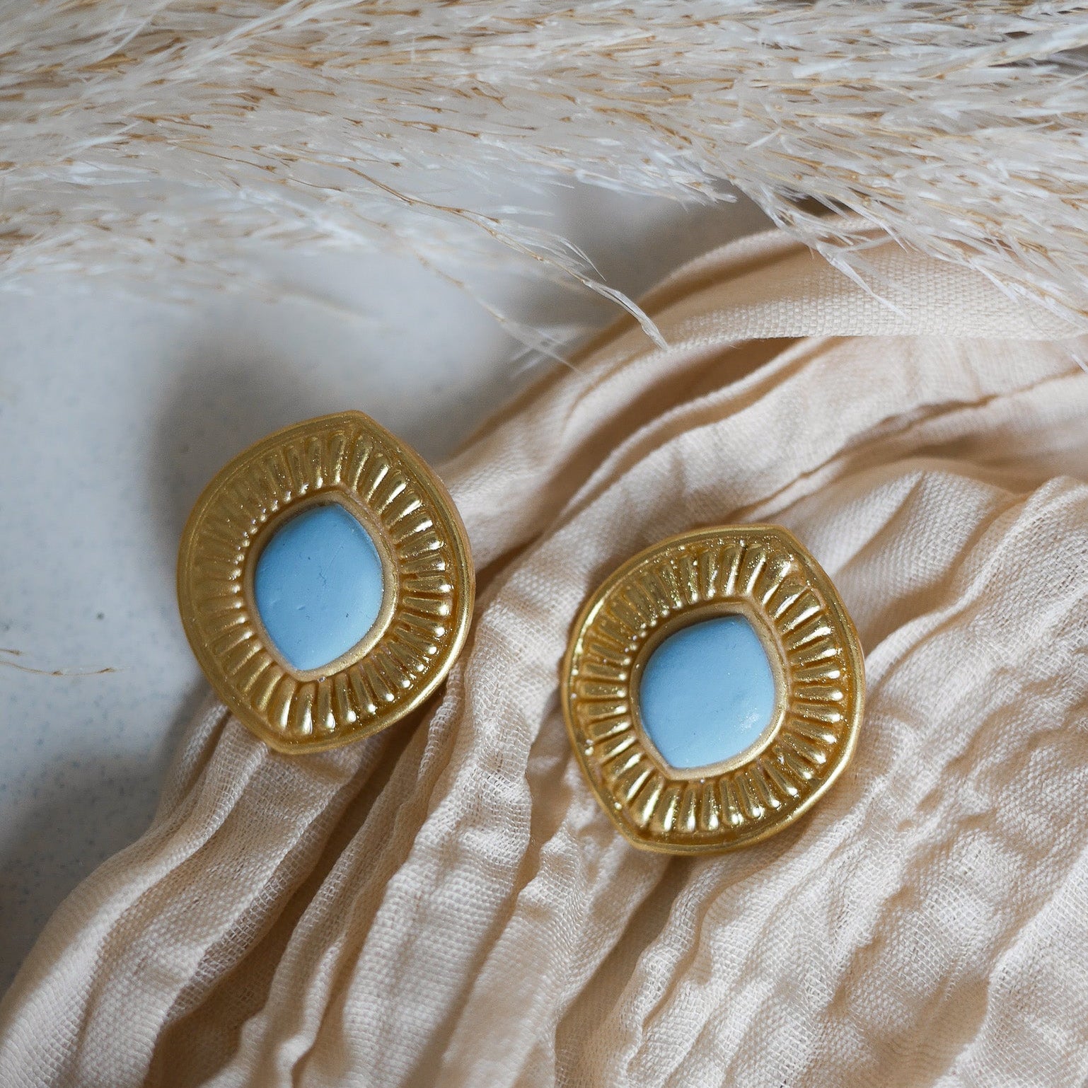 Boucles d’oreilles Manly en pâte polymère effet doré métallique, disponibles pour oreilles percées et non percées.