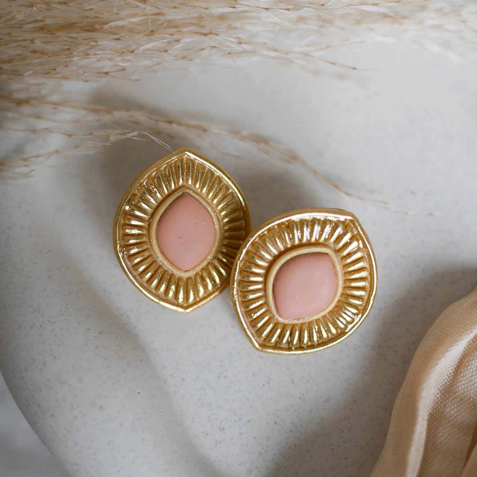 Boucles d’oreilles Manly en pâte polymère effet doré métallique, disponibles pour oreilles percées et non percées.