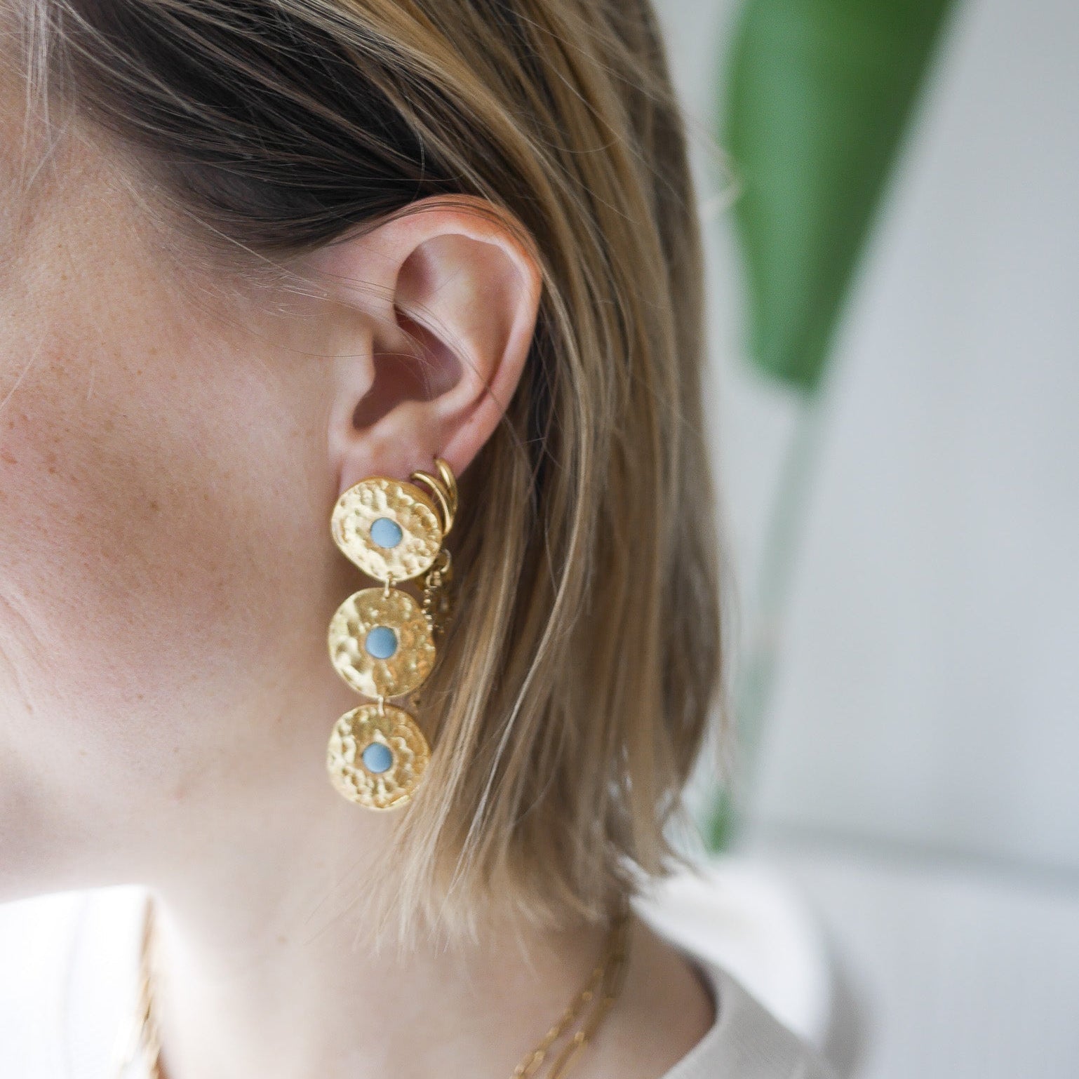 Boucles d’oreilles Byron en pâte polymère dorée, effet martelé, trois pièces articulées.