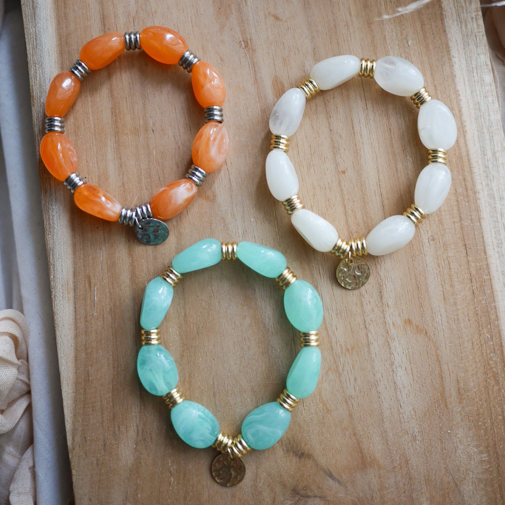 Bracelet Murano élastique avec perles colorées irrégulières, détails en acier inoxydable et breloque personnalisable.