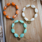 Bracelet Murano élastique avec perles colorées irrégulières, détails en acier inoxydable et breloque personnalisable.